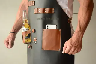 Close-up of the tan pocket and beer holder on a black apron