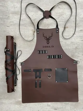 Dark brown BBQ apron with a stag logo engraved on the chest