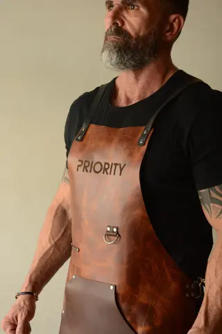 Close-up of a tan apron engraved PRIORITY