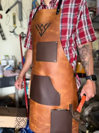 Woodworking apron in a workshop, with a hand in the front pocket